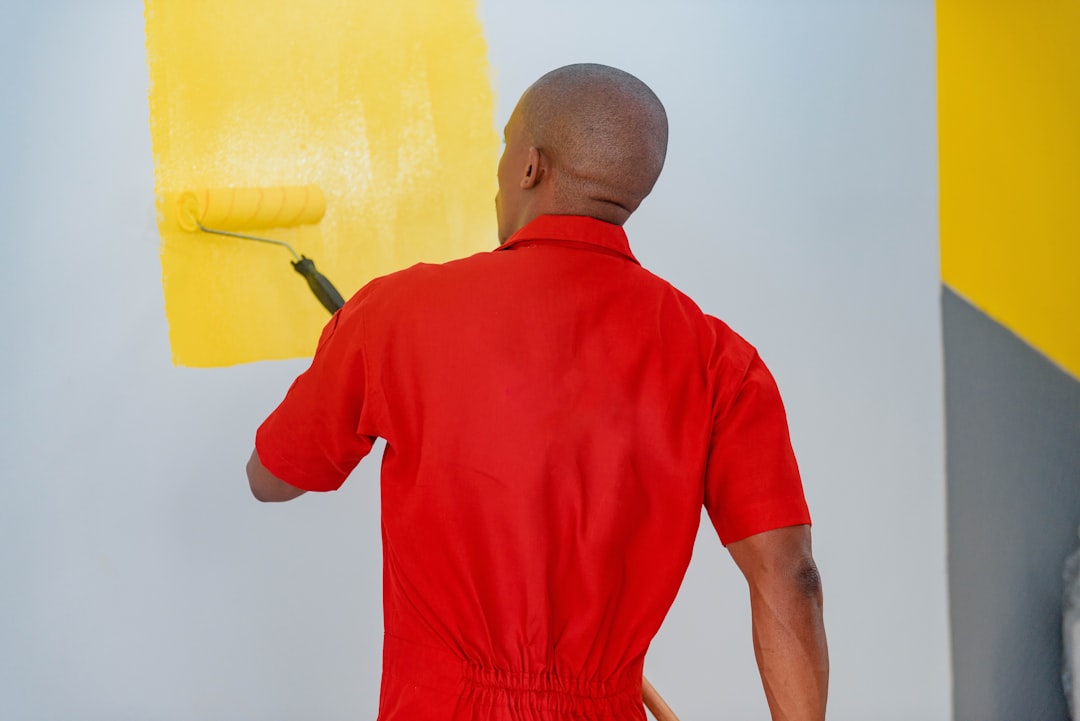 African man painting wall with a roller